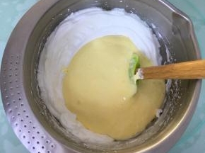 将翻拌好的蛋糕糊倒入到剩余的蛋白霜中。