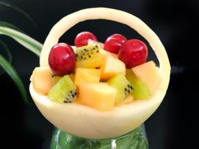 6、再把挖出来的果肉切成小块，猕猴桃也切成小块，再把樱桃放上。