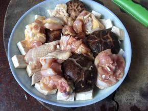 盘底放入切成小块的芋头丁，再放入泡发的香菇和腌制好的鸡腿肉