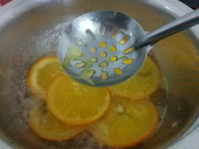 将橙片放入180g水中，再加入30克细砂糖中火熬，虑出会导致糖浆发苦的沫沫