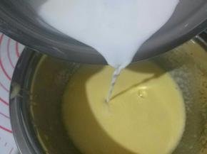 将加热的牛奶缓缓倒入蛋黄糊中，边倒边搅拌均匀，然后倒入90克鲜榨橙汁，搅拌均匀