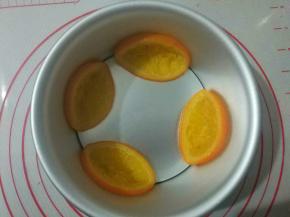 将煮熟的橙片码入六寸模具中