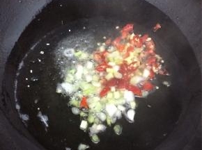 锅里倒入适量的油，等油热后，将葱、姜和辣椒加入，煸炒出香味