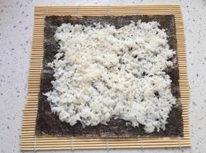 均匀的铺一层米饭，不要太厚，用勺子稍微压实