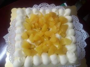 取分好的一片蛋糕，周围挤上一圈奶油，中间随意挤上一些，然后撒上一些黄桃罐头水果粒（也可以添加其他自己喜欢的其他水果）。