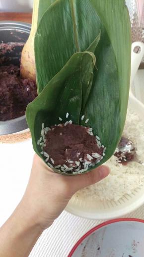 再放上一团豆沙，自己看要包多少都 可以，不要太多，因为上面还要再盖一层糯米。放好后轻轻压一压豆沙。
