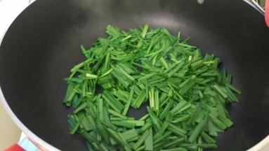 热油后加入韭菜翻炒一下。