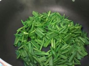 热油后加入韭菜翻炒一下。