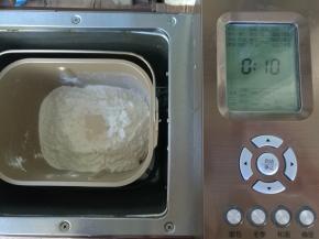 材料内除黄油外按照先液体后固体，最后面粉挖坑放酵母，启动面包机和面程序10分钟。