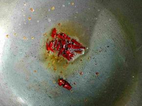 锅里放油，把干辣椒切段放入炸香