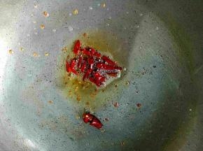 锅里放油，把干辣椒切段放入炸香