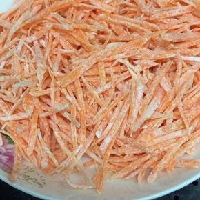 锅里加入适量的水烧开，将搅拌均匀的胡萝卜丝，放入锅中蒸三分钟