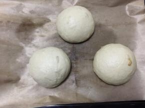 然后放入铺有油纸的烤盘中，盖保鲜膜（不要盖太紧）常温静置40分钟，或烧开一碗水放入烤箱中待水蒸汽笼罩烤箱将面包放入静置20分钟