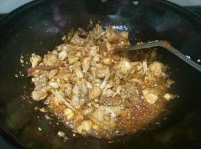 倒入酱油，让田鸡翻炒上色