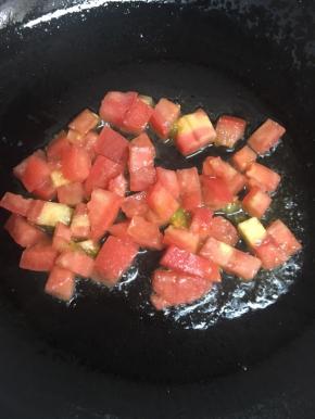 锅内倒入适量的油，加热后倒入番茄丁小火慢炒