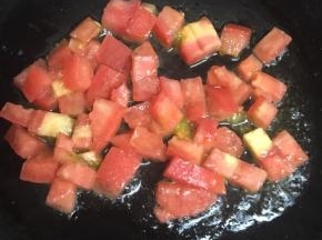 锅内倒入适量的油，加热后倒入番茄丁小火慢炒