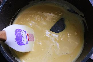 将混合均匀的蛋黄液，倒回小锅中，小火继续加热，并一直不停的搅拌，防止受热不均，导致结块（请尽量使用厚实一些的锅子喔）煮至液体变稠，倾斜，能挂住锅底，并能划出痕迹即可
（一定要用小火喔，切勿过大，否则极容易变成蛋花喔）煮好的分量，约为145-155g左右，煮好的量必须要控制在这个范围内才行，分成50g和90g两个份量，冰水冷却后，一旁备用，蛋奶酱就熬好了