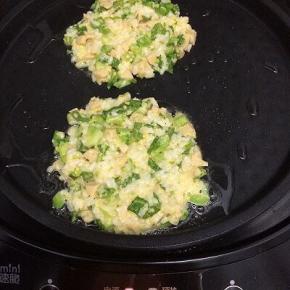 电饼档加入适量的油预热，预热好后，用勺子盛一勺，倒入锅中，用铲子给摊平，选择葱油饼键，直到鸣叫为止，打开盖子取出米饭饼