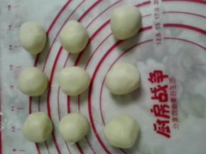 2、面包机揉油皮的时候，用手把油酥合好，面粉倒入猪油中，用手捏匀，直至揉成团。均匀分成12份。