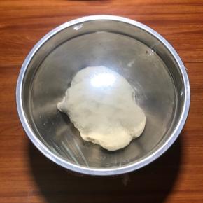 用手揉成团，成团即可， 下一步就是醒面，光滑的面团是光滑馒头的关键，然后想揉成光滑的面团，必须要醒面，盖保鲜膜，20分钟。