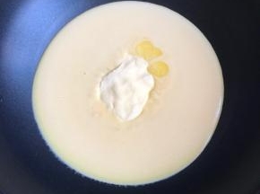 找个不粘锅，放入面糊，放入30克黄油，开最小火搅拌，炒，慢慢会变浓稠，一定是最小火