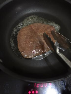 5. 把腌制的泮葱抹干净，这时洋葱还是放在碗中待用，把牛排煎至变色开始翻面