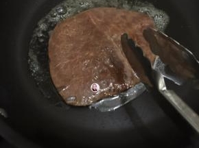 5. 把腌制的泮葱抹干净，这时洋葱还是放在碗中待用，把牛排煎至变色开始翻面