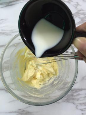 5. 蛋黄混合好之后加入纯牛奶，也是分两次加纯牛奶加进去时比较难混合，没关系的，继续打就会混合的