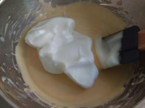 蛋黄从冰箱拿出来再搅拌均匀后加入1/3蛋白到蛋黄糊里面搅拌均匀。蛋白打好后是比较细腻发白发亮的。注意搅拌手法。前面蛋糕卷的方子有教。