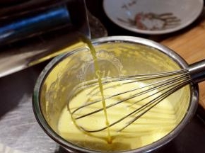 提前融化的黄油，放置降温后加入蛋黄糊，再加入柠檬皮屑，柠檬果肉，柠檬汁搅匀