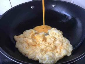 锅里放适量的油，油温5成热时放入一半的鸡蛋液，当鸡蛋液成型后用用筷子迅速把它推到锅的一边，热后再倒入另外一半的鸡蛋液，鸡蛋液成型后，迅速把所有鸡蛋滑散成自己所需要的大小块，盛出备用。这样炒鸡蛋可以省油。也适合炒量较多的鸡蛋。