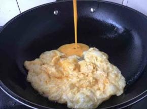 锅里放适量的油，油温5成热时放入一半的鸡蛋液，当鸡蛋液成型后用用筷子迅速把它推到锅的一边，热后再倒入另外一半的鸡蛋液，鸡蛋液成型后，迅速把所有鸡蛋滑散成自己所需要的大小块，盛出备用。这样炒鸡蛋可以省油。也适合炒量较多的鸡蛋。