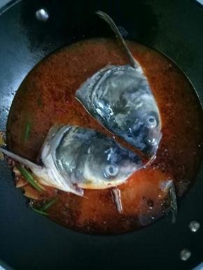 最后加入适量的开水，放入鱼头，鱼骨，大火烧开，中小火炖15分钟左右，放入料酒2茶匙，生抽1茶匙，糖1小勺，鸡精1小勺调匀