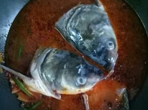 最后加入适量的开水，放入鱼头，鱼骨，大火烧开，中小火炖15分钟左右，放入料酒2茶匙，生抽1茶匙，糖1小勺，鸡精1小勺调匀