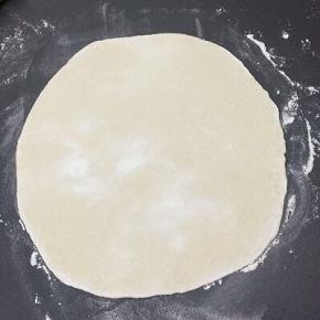 A面团饧好后，放在面板上，洒上少许面粉，将面团擀成薄片