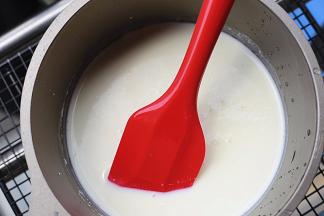 将拌匀的液体倒入奶锅中，小火加热，并用刮刀不停的搅拌，以免结块或是粘底