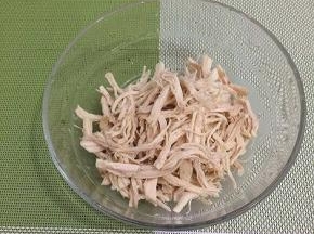 鸡胸肉晾凉，戴上一次性手套，将鸡胸肉撕成丝，装入碗中