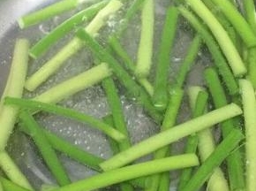 汤锅里加入适量的水和少许的盐和油烧开，将蒜苔放入焯熟