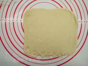 松弛好的面团用擀面杖擀成长方形面皮，底端用手指压扁，这样待会好粘合。