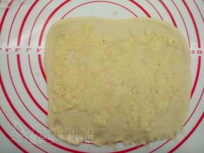 取出冷藏的椰蓉馅，分成3份，将一份椰蓉馅均匀的铺在面片上面，用擀面杖压一下。