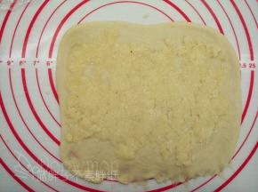 取出冷藏的椰蓉馅，分成3份，将一份椰蓉馅均匀的铺在面片上面，用擀面杖压一下。