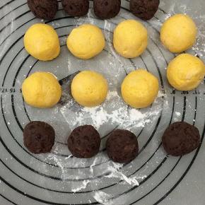 饧好的面团分成40克一个剂子搓圆，放在洒有少许面粉的垫上