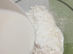 打好的花生浆用沙布过滤一下，在用秤称出150克花生浆加入到生粉中