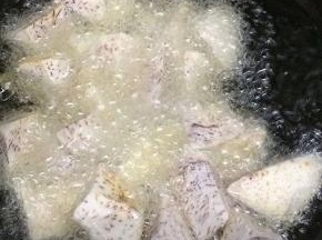 炒锅里多放一些油，等油温七成热时，下入芋头炸到变干