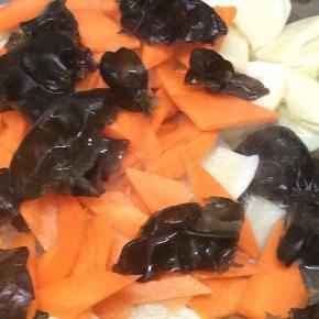 在将胡萝卜、木耳倒入翻炒均匀