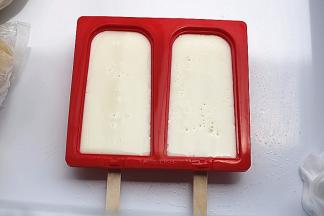 将雪糕模放平，装上雪糕棒，倒入雪糕液