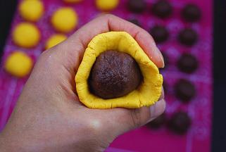 取一个南瓜小剂子压扁，包入豆沙馅