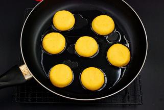 平底锅里倒入适量色拉油，微微烧热后放入压扁后的南瓜饼生坯，煎至两面金黄即可
