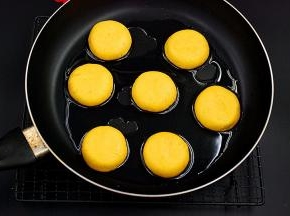 平底锅里倒入适量色拉油，微微烧热后放入压扁后的南瓜饼生坯，煎至两面金黄即可