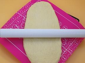 发好后的面团取出排气，尽可能擀成长方形（取出的动作不是用手直接去把面团扯出来而是用软刮板或者手指从面团的底部往上捞出来）